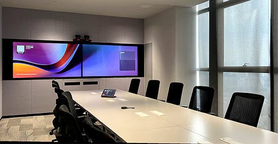 Executive boardroom with warm accent lighting, large displays, Zoom Rooms meeting
