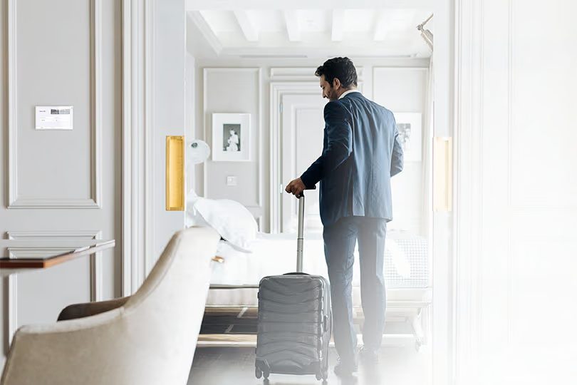 Boutique hotel guest room with warm layered lighting and balcony at golden hour